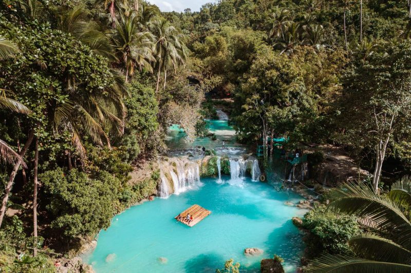 Turquoise waterfall surrounded by lush greenery